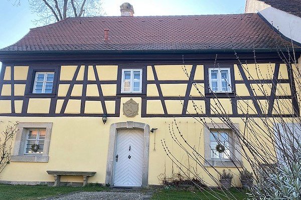 Es ist das Hofhaus im Innenhof des Schloss Adelsdorf zu sehen.